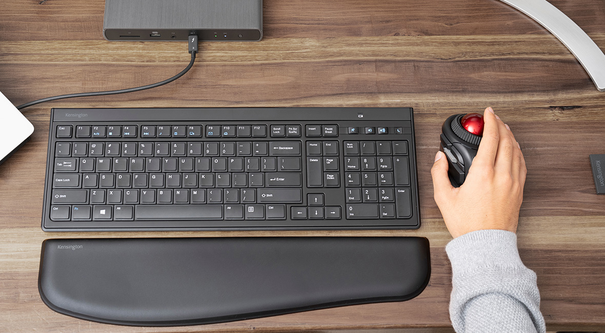 Un clavier avec repose-poignets et une main saisissant une boule de commande
