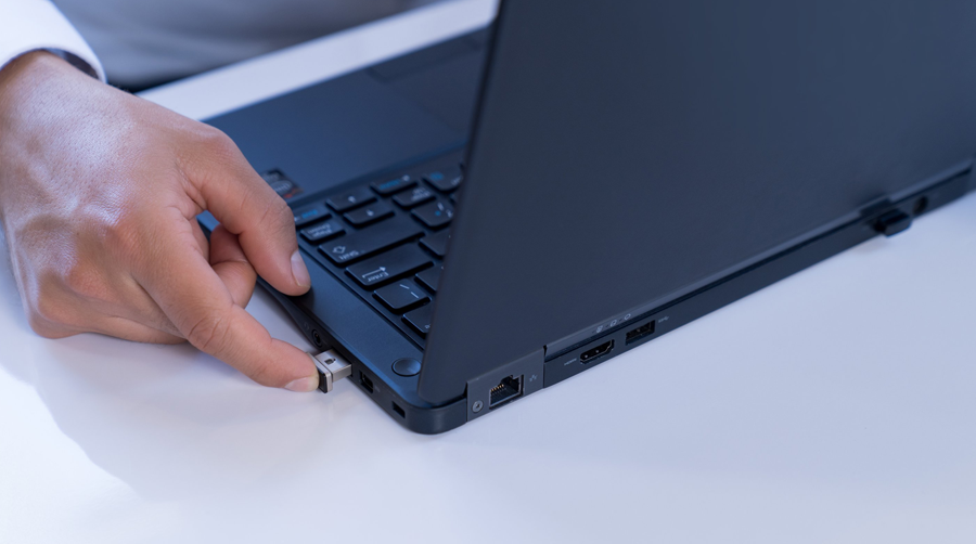 Man unlocking his laptop with his fingertip.
