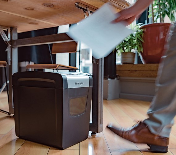 Person using Kensington paper shredder