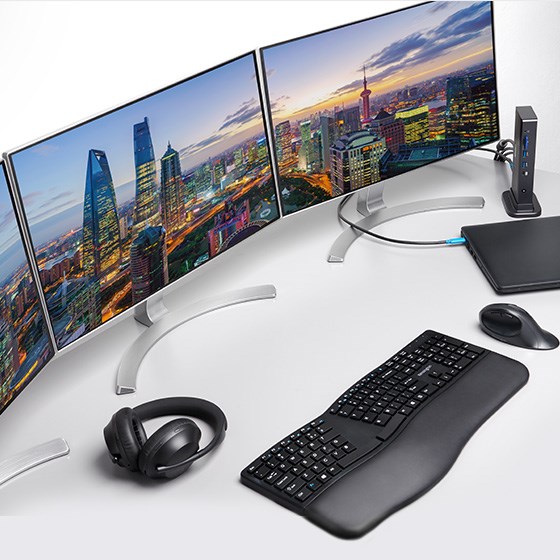 一个扩展坞将两台显示器连接至一台笔记本电脑、一个符合人体工学设计的鼠标和一个键盘以及一部手机。
