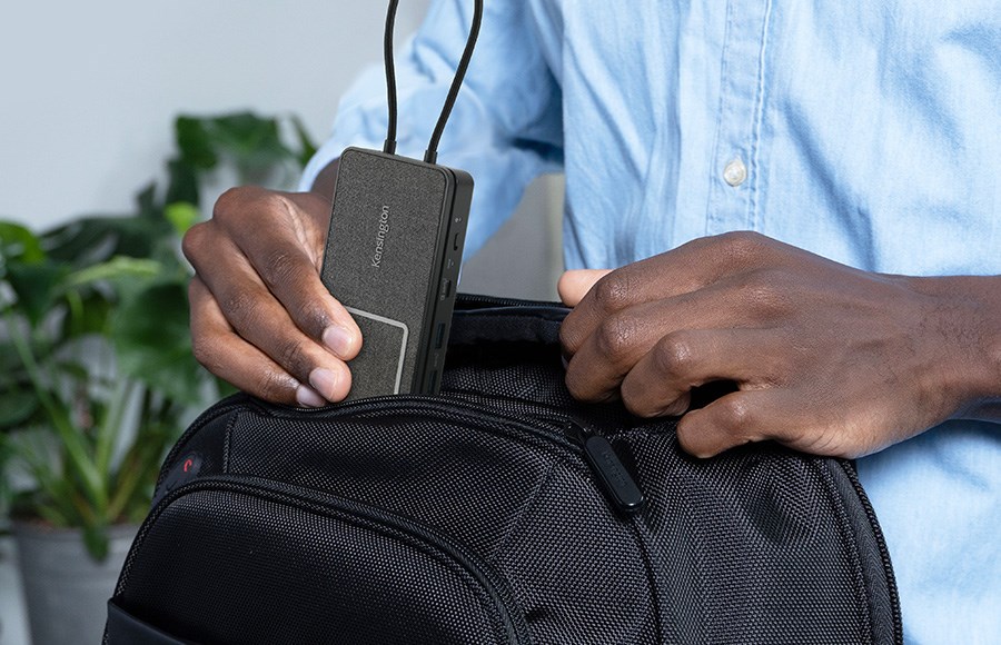 un hombre guardando fácilmente una docking station portátil en su mochila.