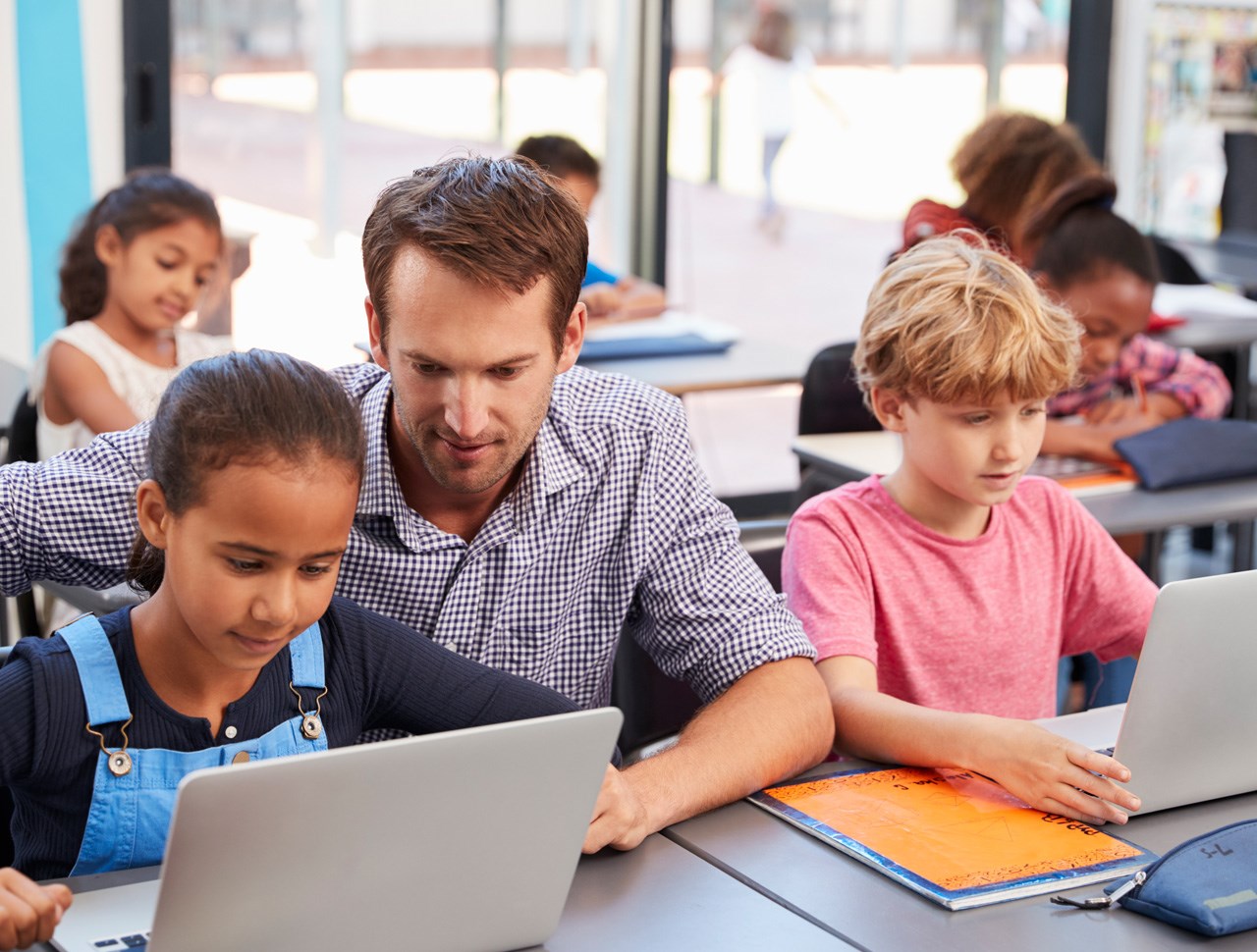 Male teacher helping student