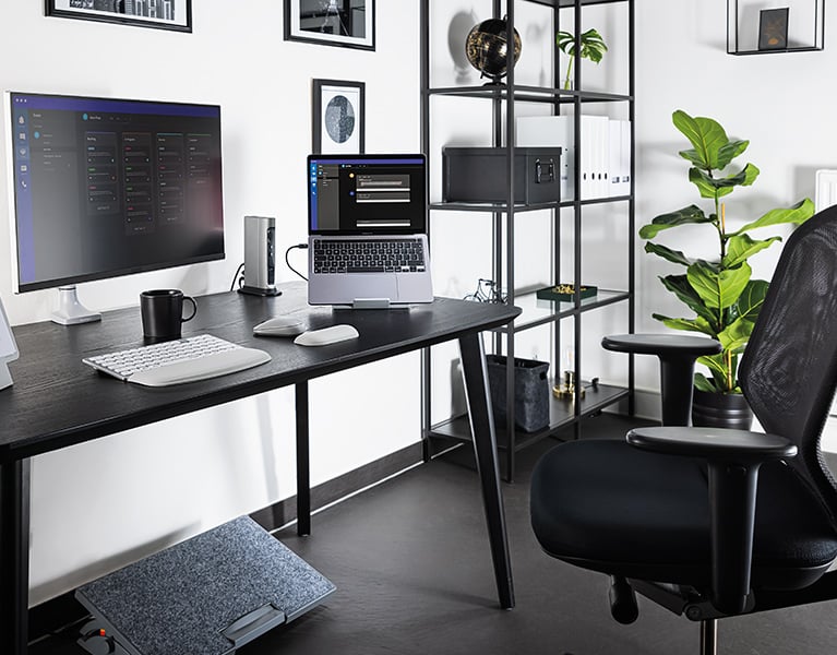 Ergonomic home office desk setup with Kensington keyboard, mouse, monitor arm, and foot rest.