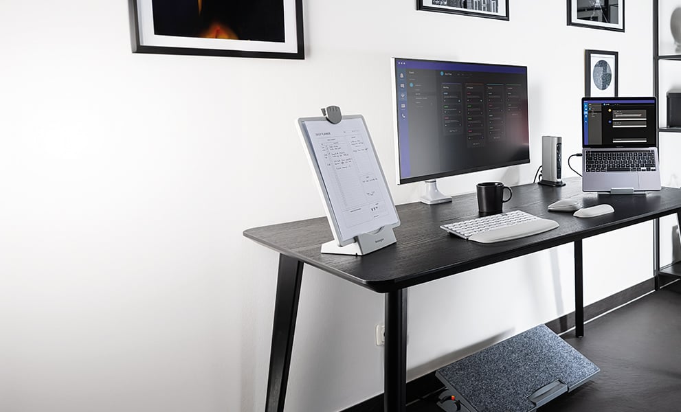 Ergonomischer Arbeitsplatz im Home Office mit Kensington Tastatur, Maus, Monitorarm und Fußstütze.