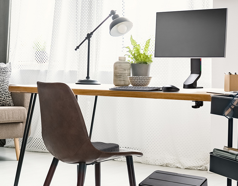 Ergonomic home office desk setup with Kensington keyboard, mouse, monitor arm, and foot rest.