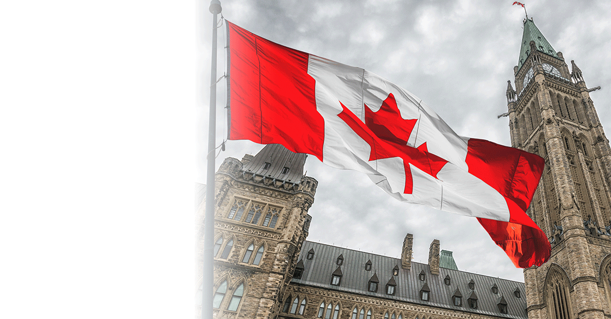 Canadian flag waving in front of Parliament Buildings in Ottawa.