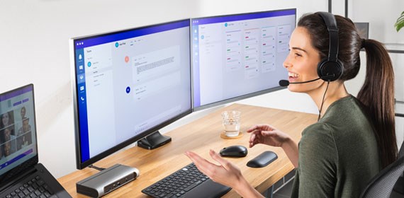 Person working at desk in home office with monitor keyboard and mouse