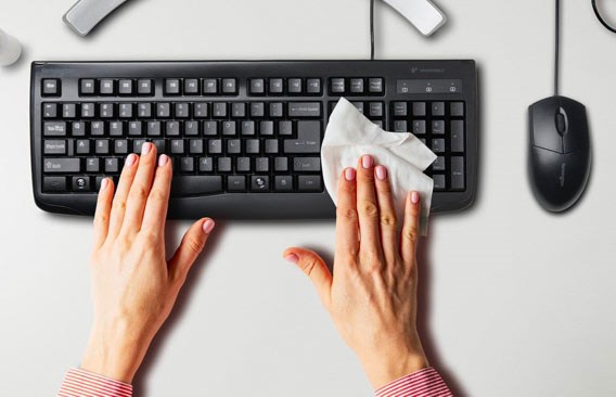 Person cleaning Kensington keyboard on white background