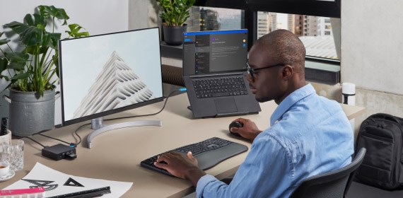 Man working at desk in home office with monitor keyboard and mouse
