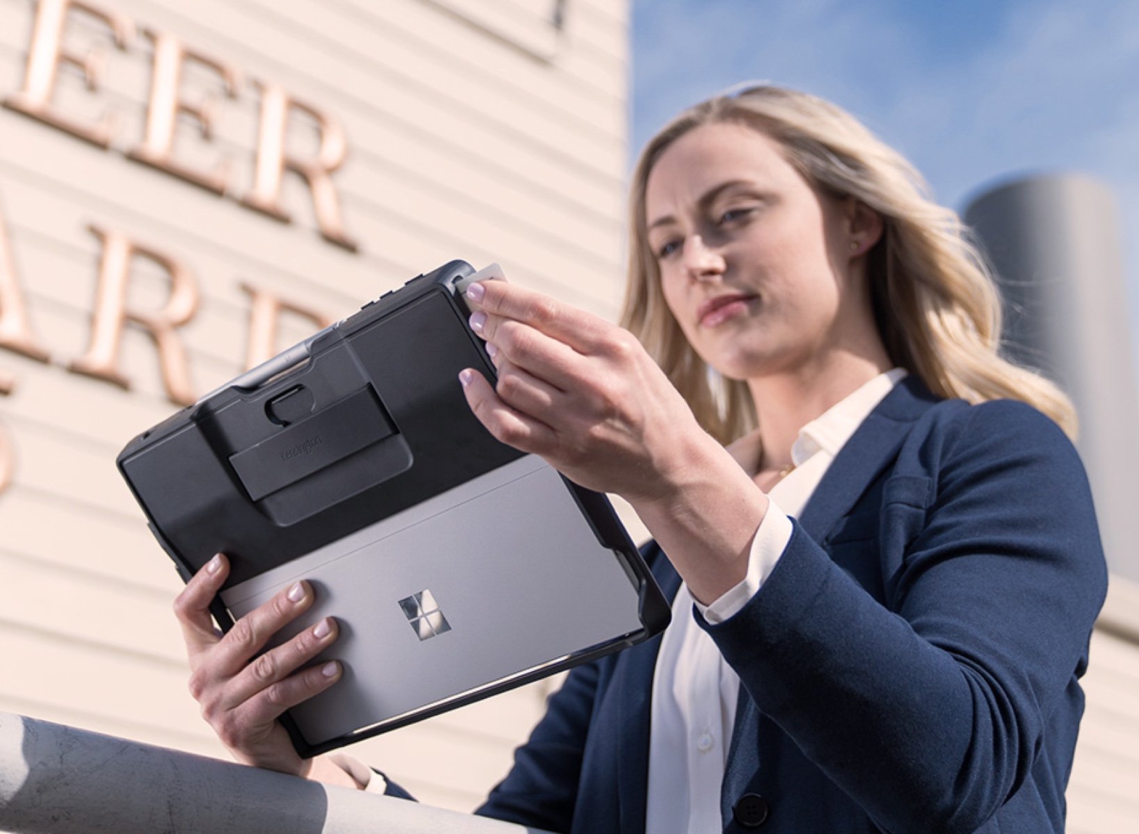 Women walking on the street and using her tablet covered with a case.