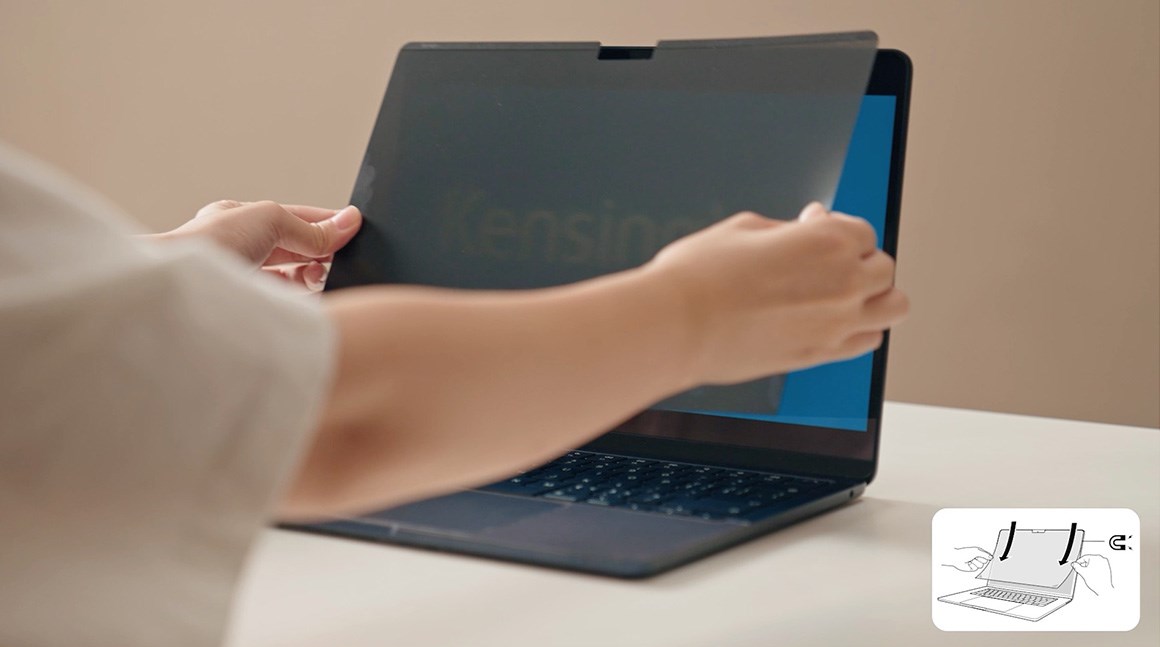 Woman placing the Kensington MagPro™ privacy screen on a laptop.