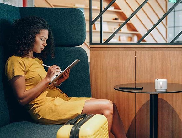 Blog: woman sitting in public using a Kensington Privacy Screen on her tablet.