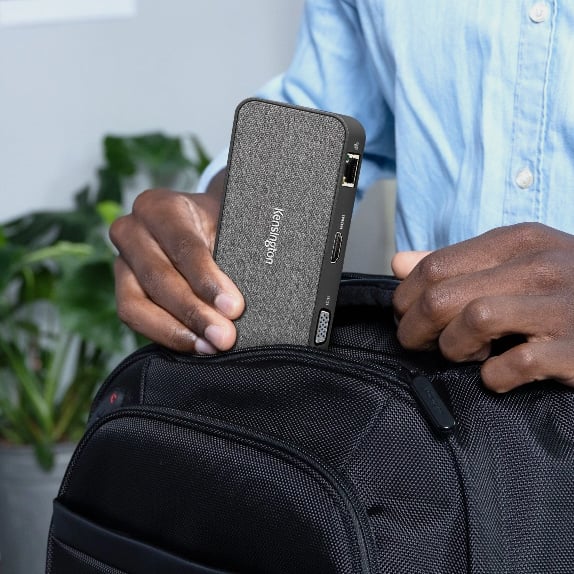 Man putting Kensington mobile docking station in backpack