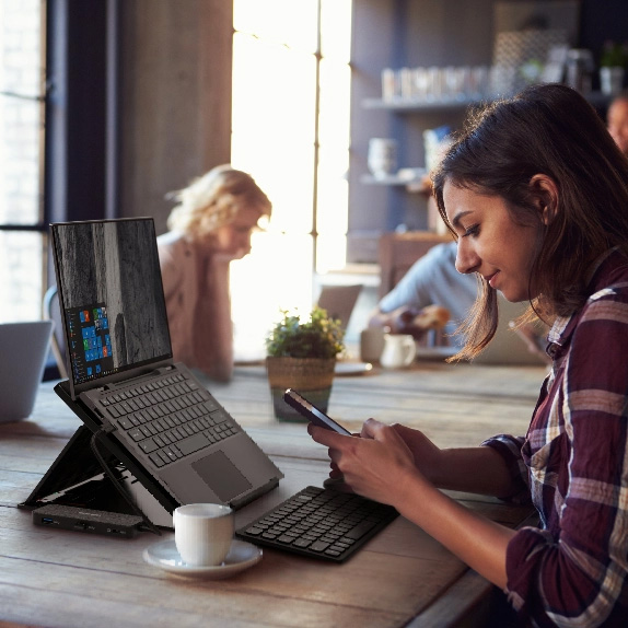 Woman using Kensington laptop riser in cafe